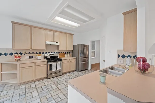 a kitchen with granite countertop a sink appliances and cabinets