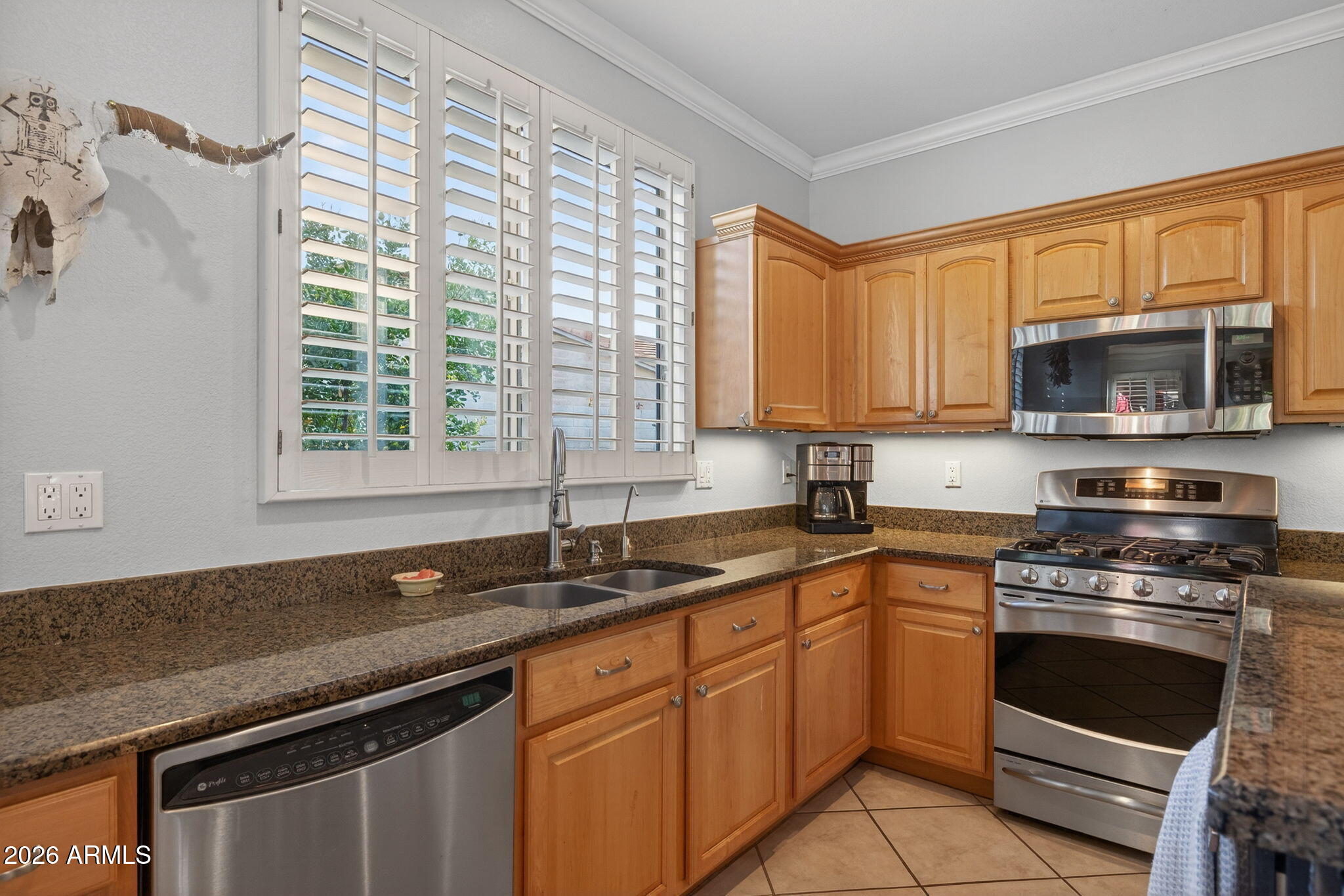 1622 West Nighthawk Way Phoenix, AZ 85045 - Photo 18 of 70 a kitchen with stainless steel appliances granite countertop a sink a stove a microwave and wooden cabinets