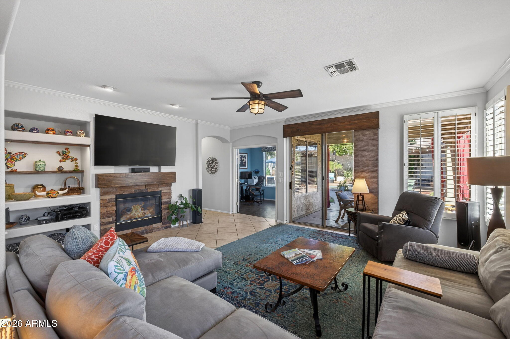 1622 West Nighthawk Way Phoenix, AZ 85045 - Photo 22 of 70 a living room with furniture a fireplace and a flat screen tv