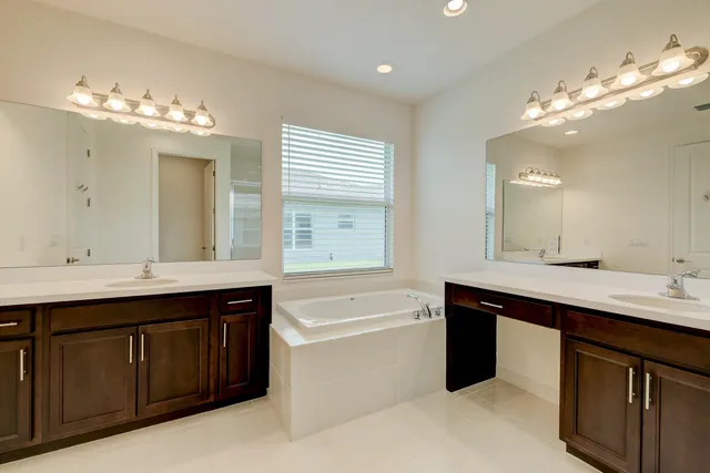 a bathroom with a sink vanity granite toilet and a mirror