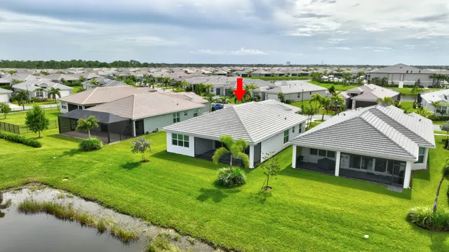 a view of swimming pool with lawn chairs and plants