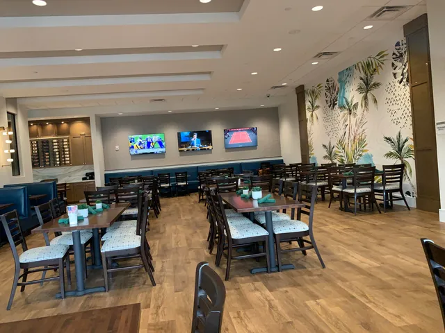 a kitchen with stainless steel appliances kitchen island granite countertop a table chairs and a refrigerator