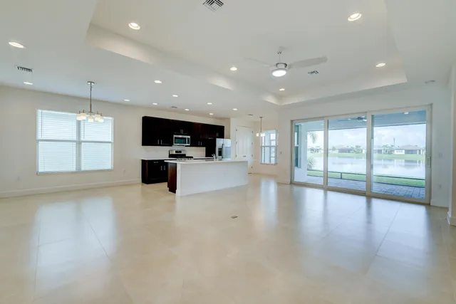 a kitchen with stainless steel appliances granite countertop a refrigerator a sink a stove top oven and a refrigerator with wooden floor