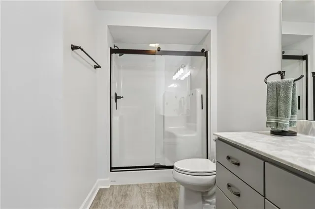 a bathroom with a granite countertop sink toilet and shower