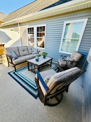 a view of a patio with table and chairs under an umbrella