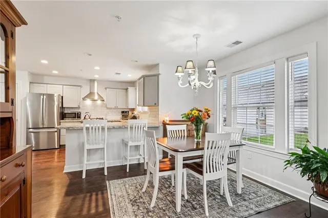 a dining room with furniture a chandelier and wooden floor