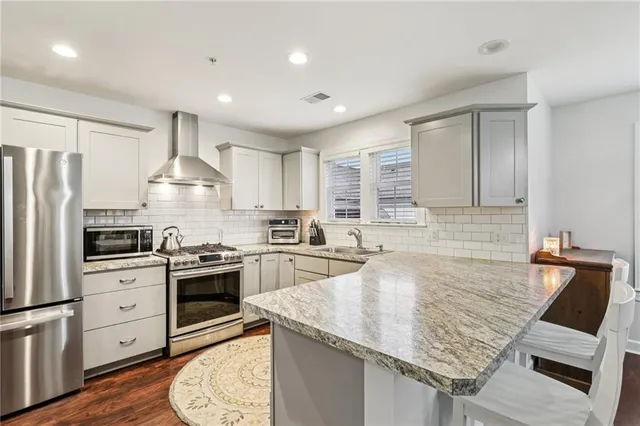 a kitchen with granite countertop a sink stove and refrigerator