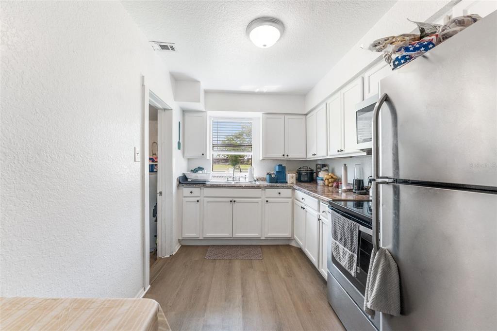 652 North Jackson Street Eagle Lake, FL 33839 - Photo 12 of 30 a kitchen with a sink a refrigerator and cabinets