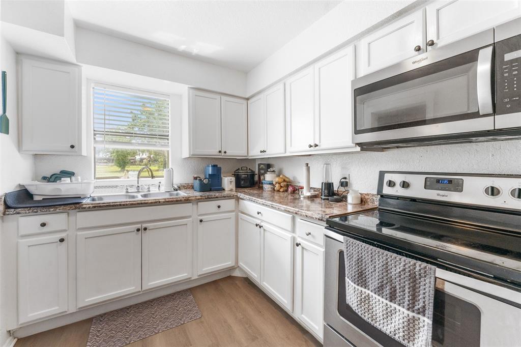 652 North Jackson Street Eagle Lake, FL 33839 - Photo 13 of 30 a kitchen with stainless steel appliances granite countertop a stove a sink and a microwave