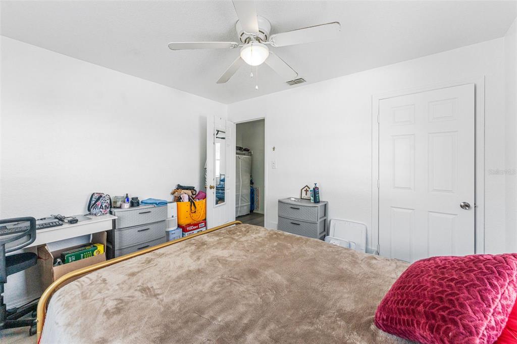 652 North Jackson Street Eagle Lake, FL 33839 - Photo 16 of 30 a bedroom with a bed and a chandelier