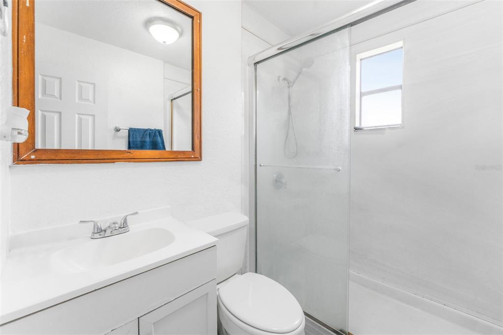 652 North Jackson Street Eagle Lake, FL 33839 - Photo 17 of 30 a bathroom with a sink toilet a mirror and shower