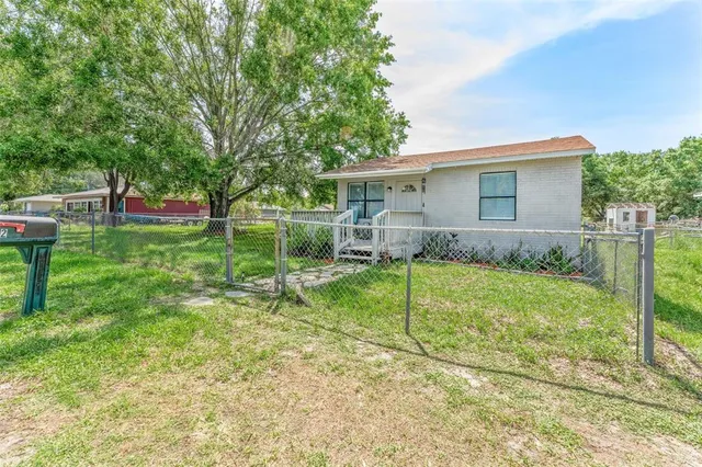 a view of a house with backyard and a tree