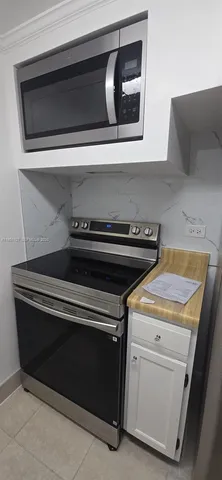 a white refrigerator freezer and a stove sitting inside of a kitchen