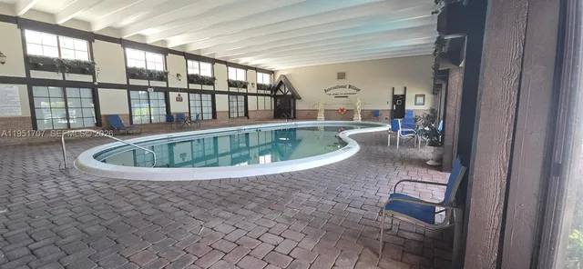 a room with pool table and windows