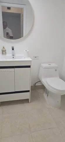 a bathroom with a sink toilet and mirror