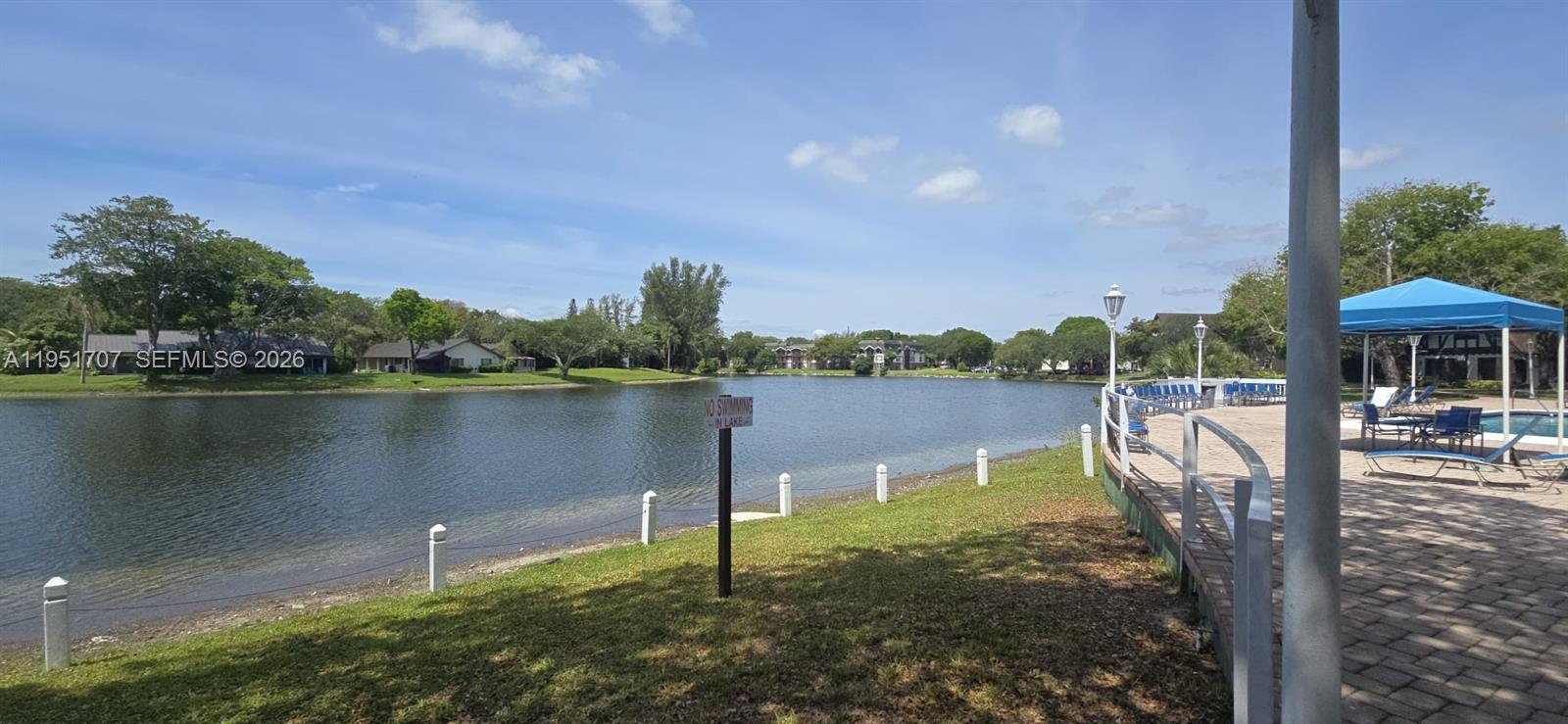3680 Inverrary Drive, Unit 3M Lauderhill, FL 33319 - Photo 59 of 60 a view of a lake with a table and chairs next to a yard