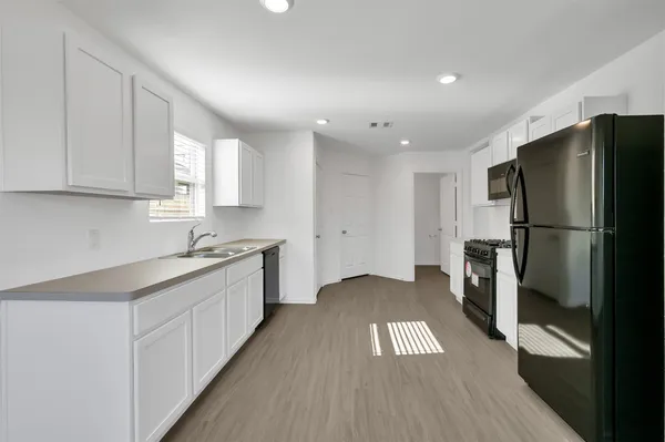 a kitchen with a refrigerator and a sink