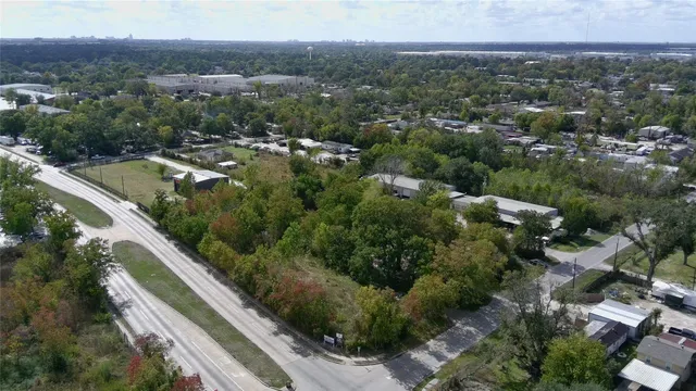 an aerial view of residential houses with outdoor space and trees