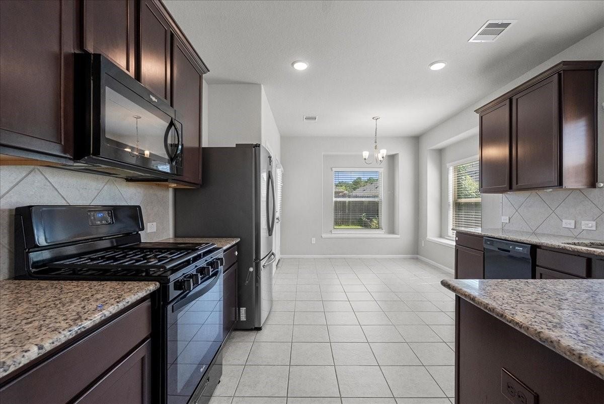 5111 Bay Lane Bacliff, TX 77518 - Photo 12 of 37 a kitchen with stainless steel appliances granite countertop a stove a sink and a microwave