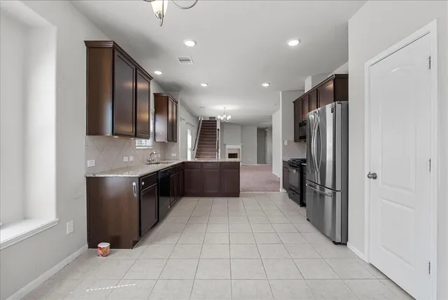 a large kitchen with a large counter top stainless steel appliances and cabinets