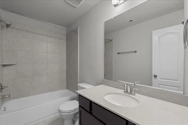 a bathroom with a granite countertop sink a toilet and shower