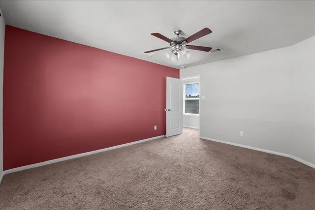 an empty room with a view and a ceiling fan