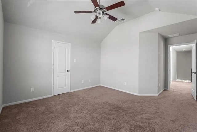 an empty room with closet and a ceiling fan