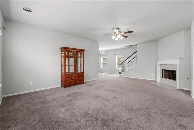a view of empty room with fireplace and fan