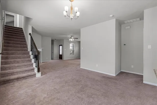a view of a livingroom with wooden floor and stairs