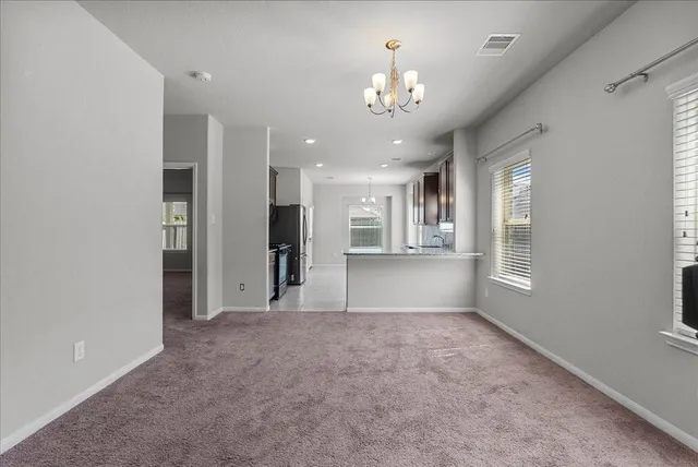 a view of a big room with windows and chandelier