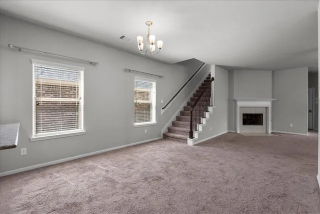 a view of an empty room with a fireplace and a window