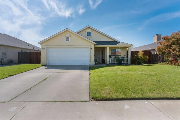 a front view of house with yard and garage