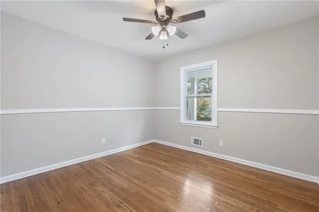 an empty room with a window and a ceiling fan