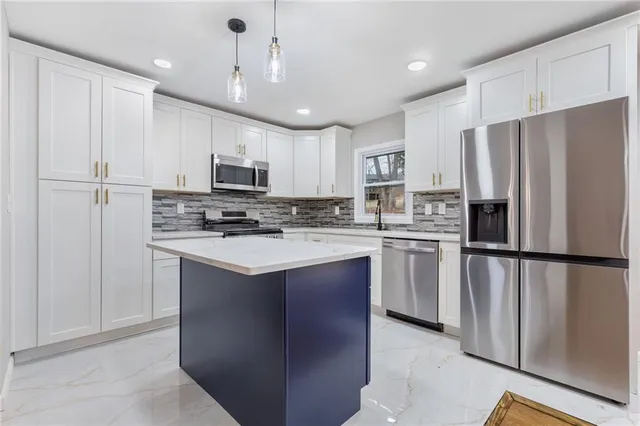 a kitchen with stainless steel appliances granite countertop a refrigerator stove microwave and sink