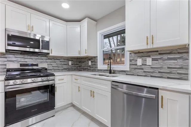a kitchen with cabinets stainless steel appliances a sink and a counter space