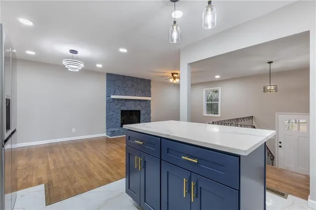 a kitchen with a sink chandelier and a fireplace