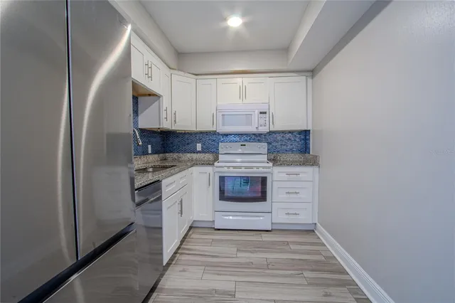 a kitchen with a stove cabinets and a refrigerator