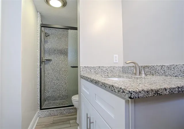 a bathroom with a granite countertop sink and a mirror