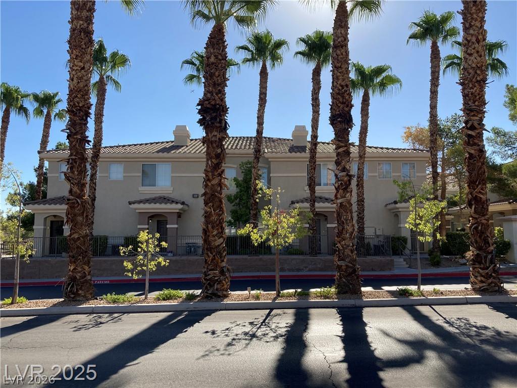 9050 West Warm Springs Road, Unit 1027 Las Vegas, NV 89148 - Photo 1 of 44 Tropical palms frame this residential structure, offering serene curbside appeal.