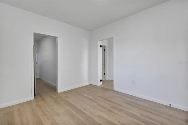an empty room with wooden floor and closet
