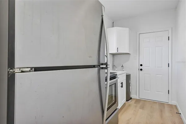a kitchen with a refrigerator and a stove top oven