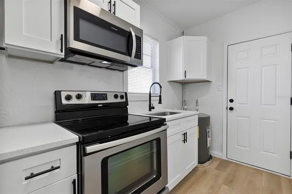a kitchen with stainless steel appliances granite countertop a stove microwave and sink