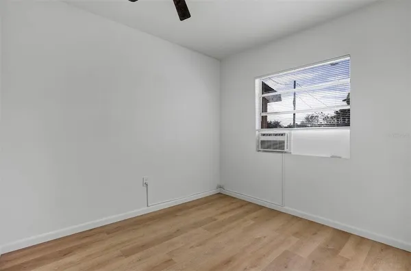 a view of a small space with wooden floor and a window