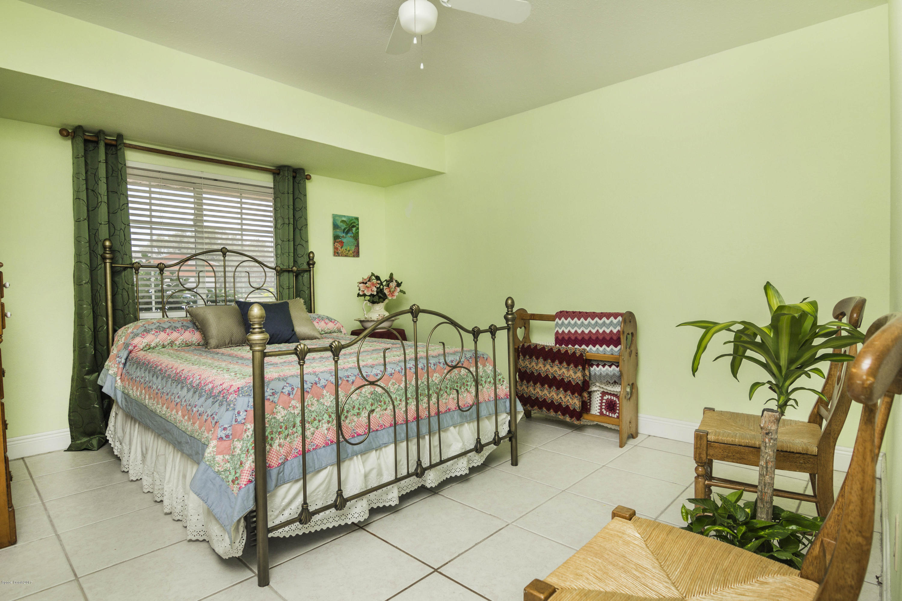 905 Riviera Drive Northeast Palm Bay, FL 32905 - Photo 12 of 21 a bedroom with a bed and a chair
