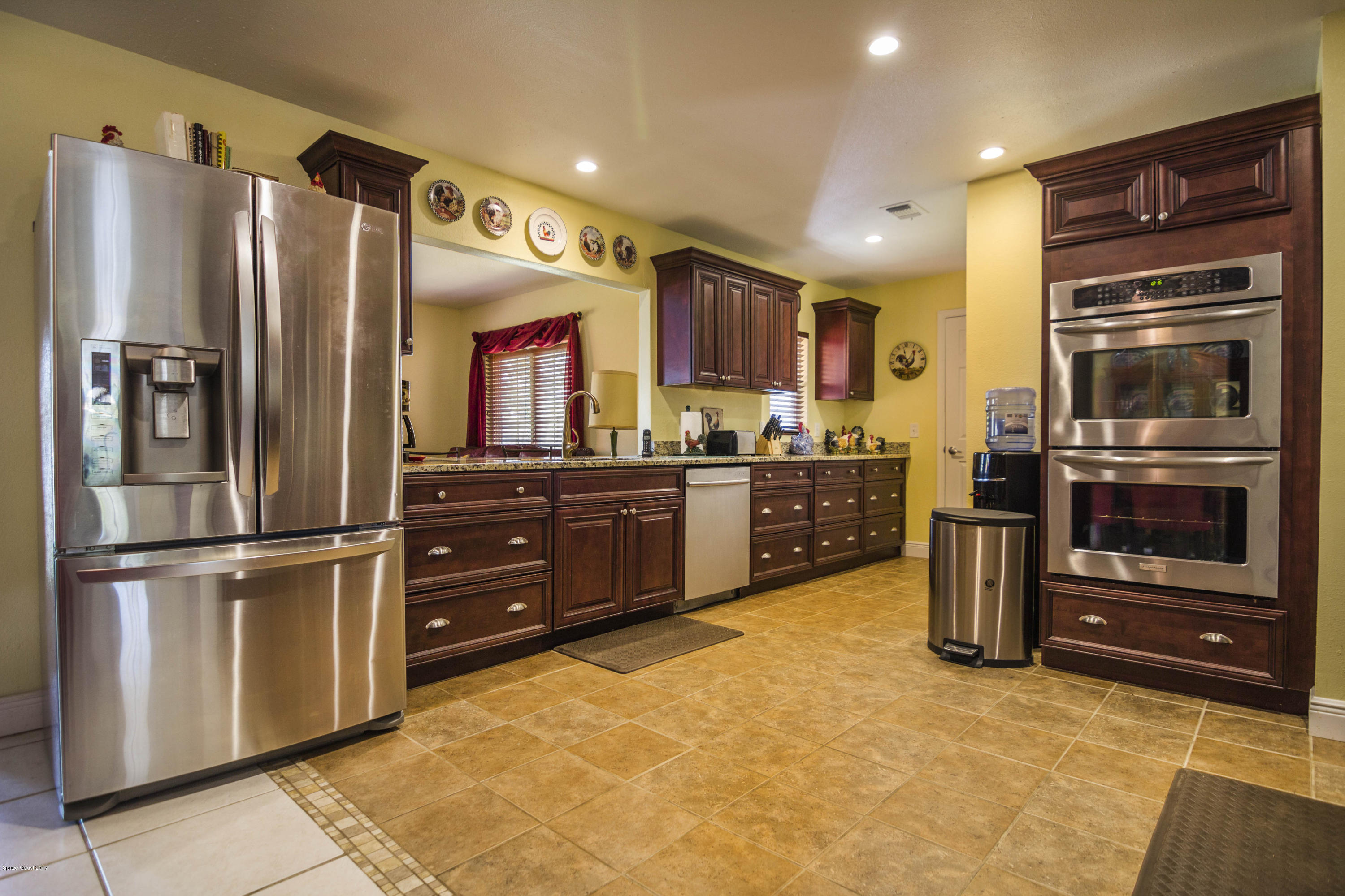 905 Riviera Drive Northeast Palm Bay, FL 32905 - Photo 5 of 21 a kitchen with stainless steel appliances granite countertop a refrigerator and a stove