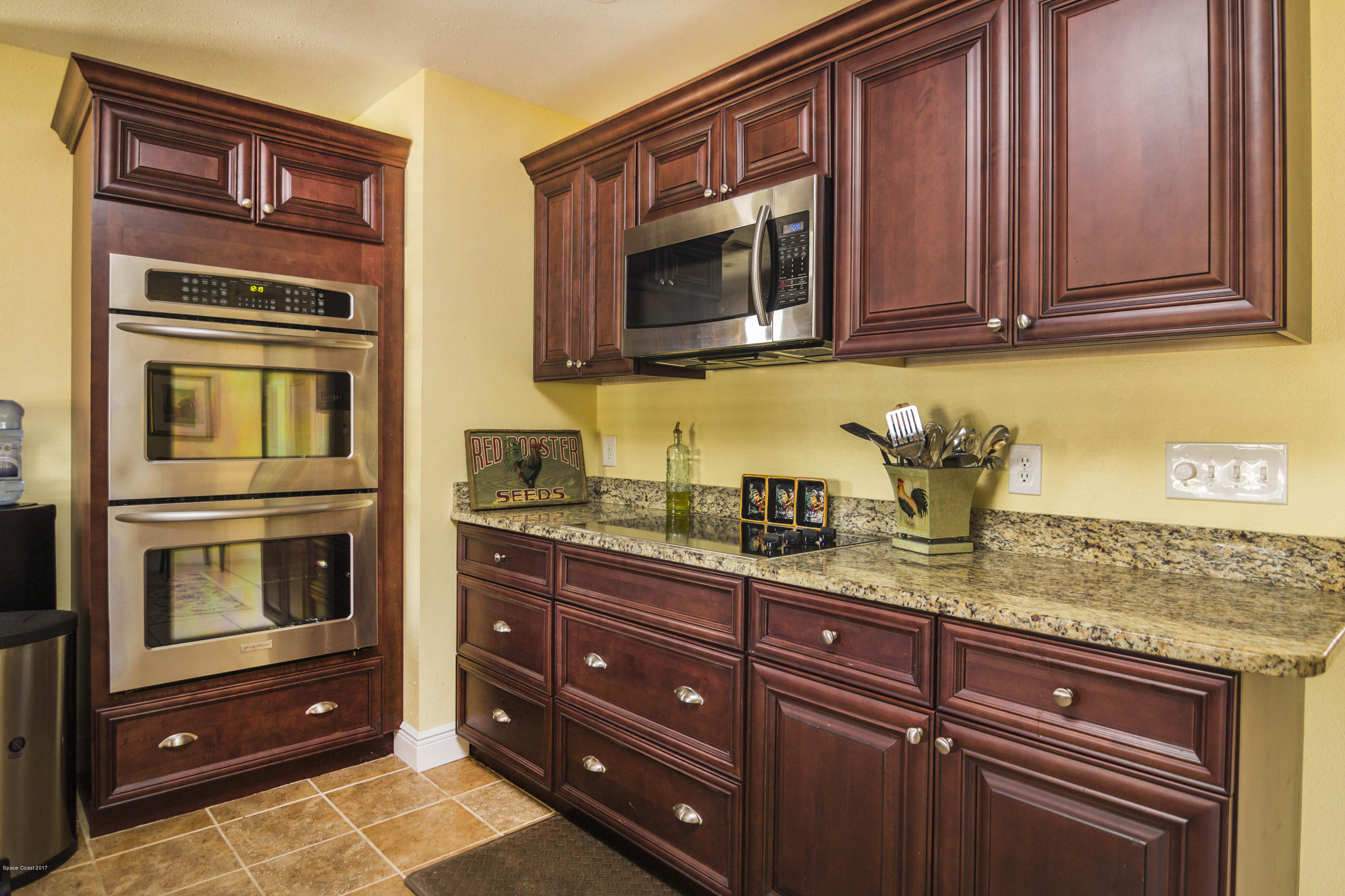 905 Riviera Drive Northeast Palm Bay, FL 32905 - Photo 6 of 21 a kitchen with stainless steel appliances granite countertop cabinets and a microwave oven