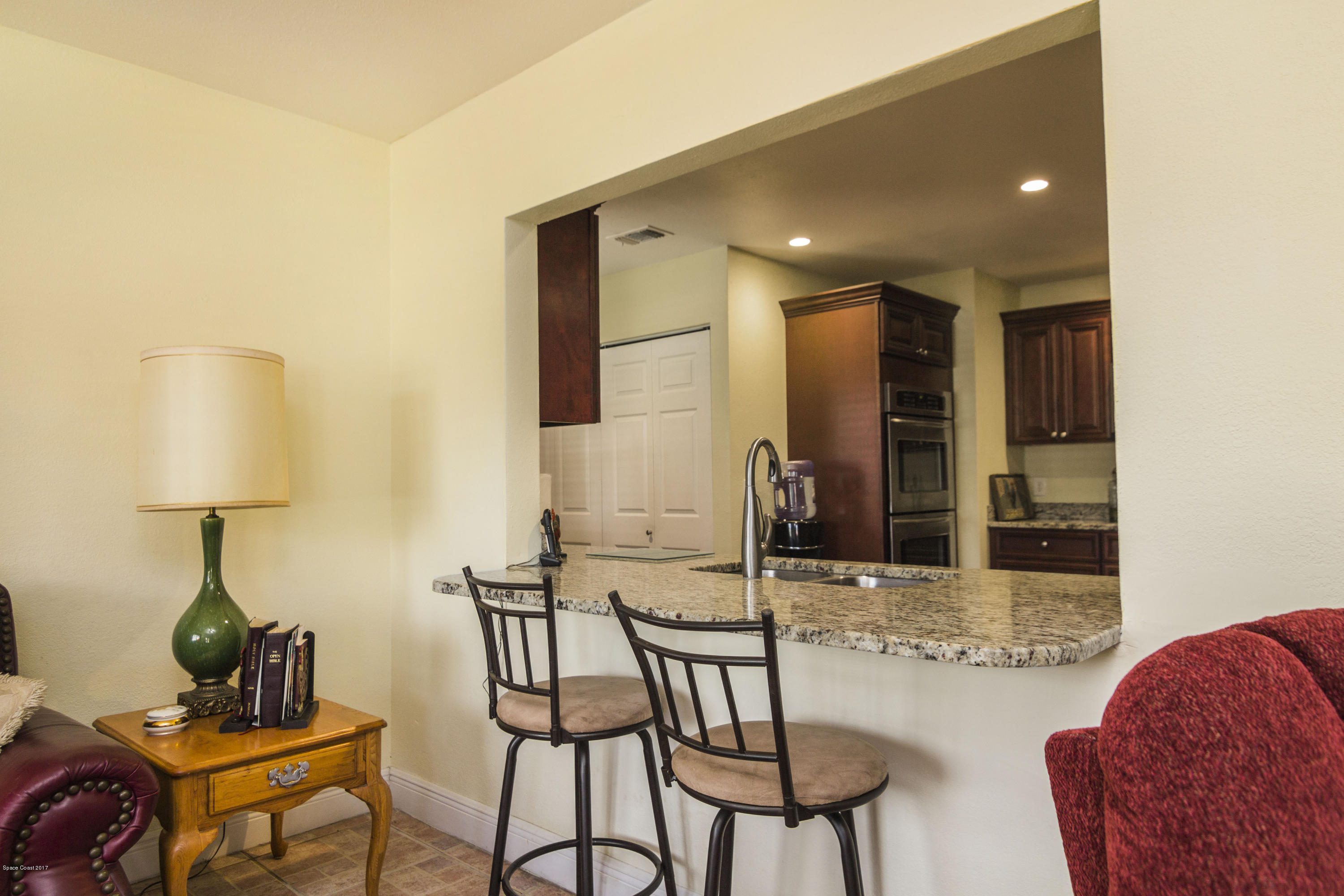 905 Riviera Drive Northeast Palm Bay, FL 32905 - Photo 9 of 21 a kitchen with stainless steel appliances kitchen island granite countertop a sink and cabinets