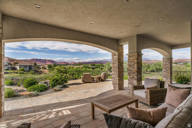 2608 Canyon Ridge Drive St. George, UT 84770 - Photo 77 of 86 Expansive covered patio featuring stone-clad pillars, arched openings, recessed lighting, and a paver stone surface