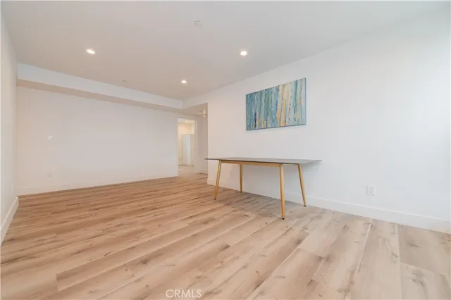 a view of empty room with wooden floor and window