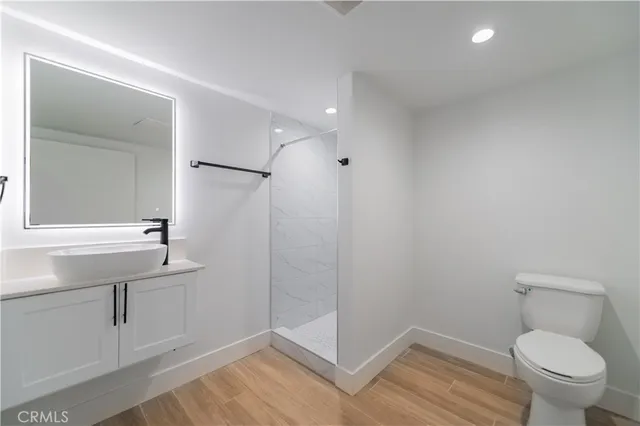 a bathroom with a sink a toilet a mirror and shower